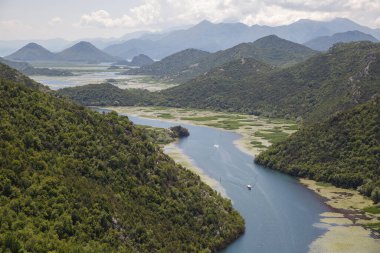 Dağlar arasında akan bir nehir manzarası, Skadar Gölü, Karadağ.