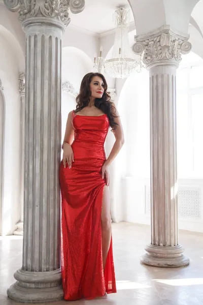 Όμορφη Μελαχρινή Γυναίκα Ένα Μακρύ Κόκκινο Λαμπερό Φόρεμα Ένα Φωτεινό — Φωτογραφία Αρχείου