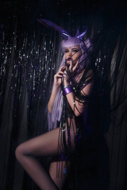 Esrarengiz bir karanlık ortamda uzun leylak saçlı seksi bir kadın..