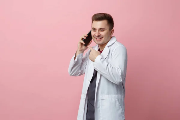 Young Doctor White Coat Emotionally Talking Cell Phone Isolated Pink — Stock Photo, Image