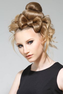 Açık arkaplanda yaratıcı saç stili olan bir kızın moda portresi..