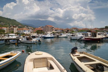 Limandaki tekne ve tekneler, kentin ve dağların zeminine karşı, Tivat, Karadağ.