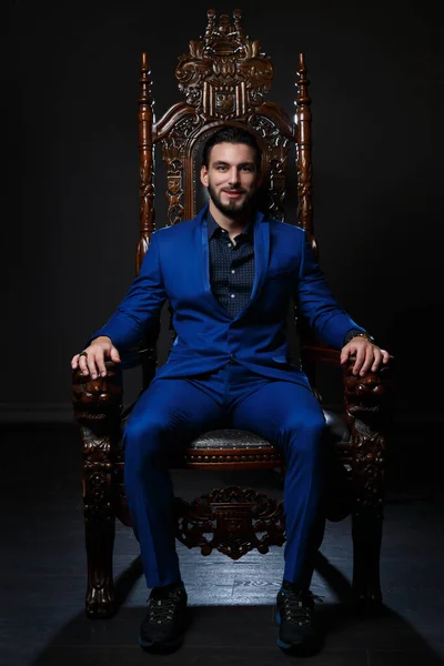 Homem Elegante Terno Azul Clássico Sentado Uma Cadeira Madeira Esculpida — Fotografia de Stock