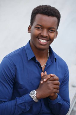 Neşeli, gülümseyen, çekici, mavi gömlekli siyah adam dışarıda..