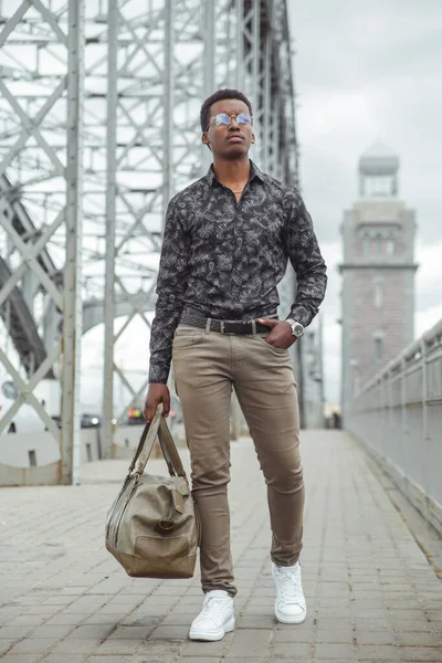 Joven Negro Atractivo Con Una Gran Bolsa Mano Cruza Puente — Foto de Stock