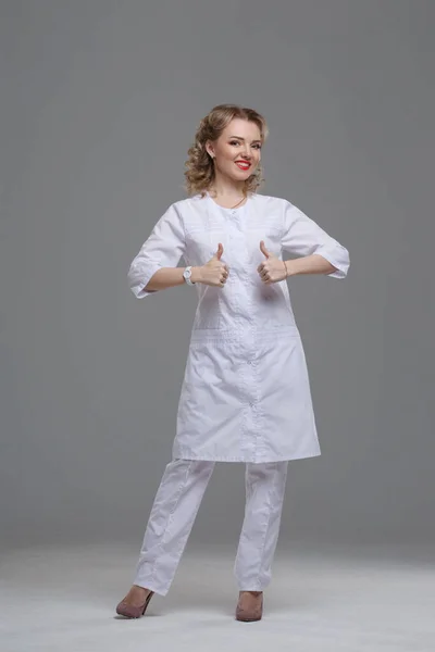 Uma Médica Sorrindo Menina Uniforme Médico Mostra Gesto Polegar Levantado — Fotografia de Stock