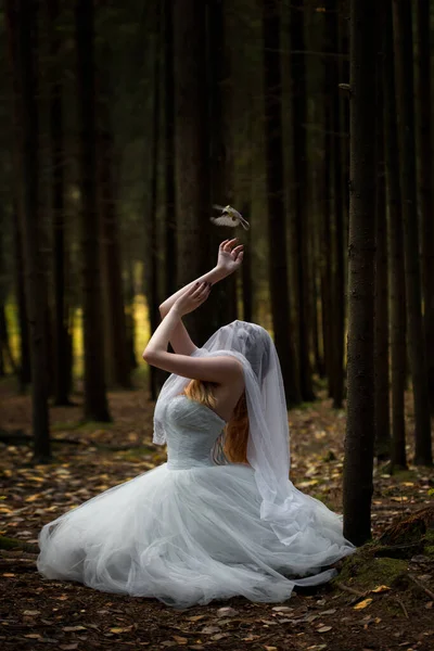一个神秘的女人新娘 在阴森森的森林里 戴着面具 头戴祈祷帽 一只小鸟爬进了她的手 — 图库照片