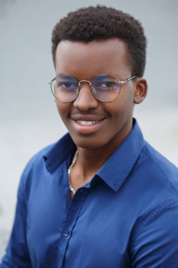 Neşeli, gülümseyen, çekici, mavi gömlekli siyah adam dışarıda..