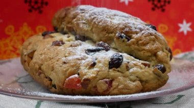 Stollen 'a bol miktarda pudra şekeri serpiyorum. Kurutulmuş meyve ve fındıkla dolu lezzetli bir maya keki. Klasik Alman Noel Kurabiyeleri