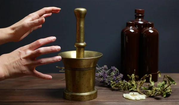 Simyacı ya da büyücünün okült sanatı üzerinde çalış. Büyüler için sihirli karışımlar için malzemelerin sıralanma süreci. Pestle kasedeki malzemeleri ezer.