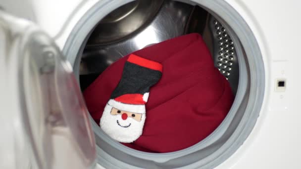 圣诞老人把红帽子 红袜和圣诞树套放进洗衣机里 准备圣诞节和新年假期 圣诞幽默 恶作剧和欢乐 — 图库视频影像