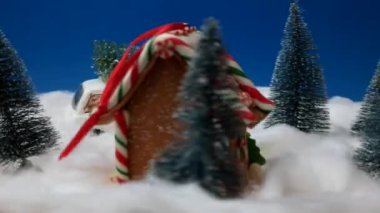 Noel ve Yeni Yıl dekorasyonu. Oyuncak Noel Baba ve zencefilli kurabiye eviyle muhteşem bir kış akşamı sahnesi. Noel 'i kutluyoruz. Mutlu Noeller.