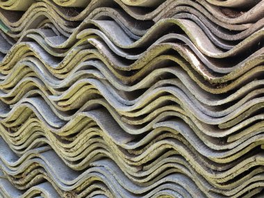 Yumuşak, dalgalı levhalar, yakın çekim. Eski çatı tahtası deposu. Oluklu asbest-çimento çarşafları