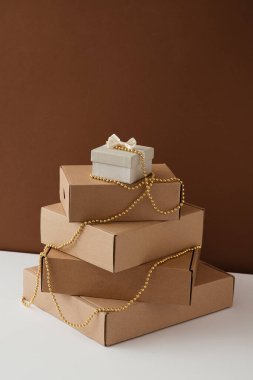Noel hediyeleri beyaz, kahverengi arka planla süslenmiş kutularda. Minimum Yeni Yıl tatili kavramı.