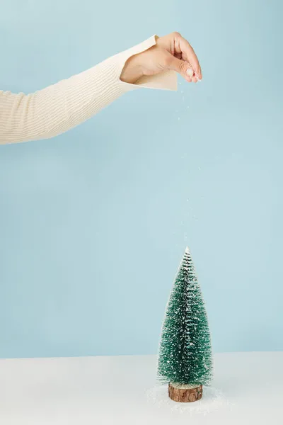 Vrouwenhand Bedekt Sneeuw Pijnboom Pastel Blauwe Achtergrond Minimaal Kerstconcept — Stockfoto