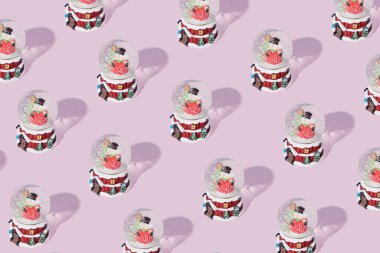 XMas kar küresiyle yapılmış Noel deseni Pastel Pembe arka plana karşı kardan adam. Retro tasarımı..