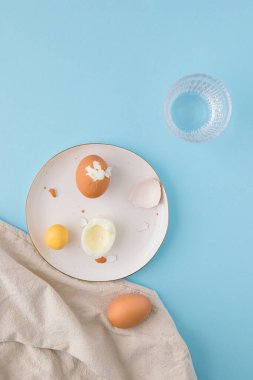Üç pişmiş yumurta ve bir bardak su ile sabah sahnesi. Paskalya ve sağlıklı gıda konsepti..