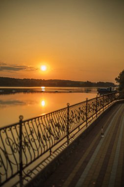 Gölün üzerinde gün batımı. Rıhtım. Turuncu gün batımı