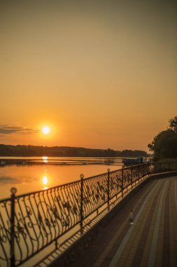 Gölün üzerinde gün batımı. Rıhtım. Turuncu gün batımı
