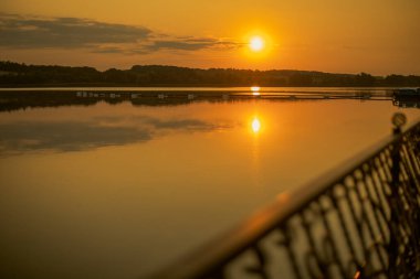 Gölün üzerinde gün batımı. Rıhtım. Turuncu gün batımı