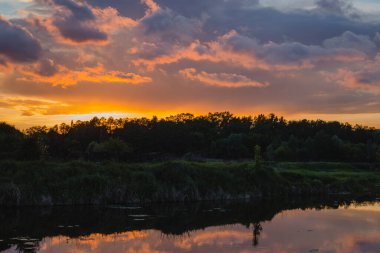 Güzel kıyı şeridi. Nehirle aydınlık yaz günbatımı