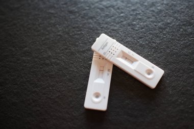 Antijen testleri negatif sonuç verdi. Kırmızı kontrol hattı. Siyah arkaplan 