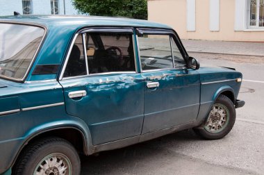 Eski hasarlı araba Tomsk, Sibirya 'da boş bir caddeye park edilmiş. Mavi renk, insan yok. Rusya.