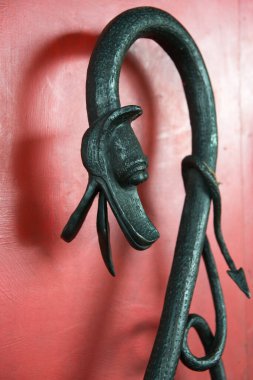 Metal ejderha kafası ve kuyruğu olan eşsiz bir korkuluk. Kırmızı arka plan. Londra, İngiltere