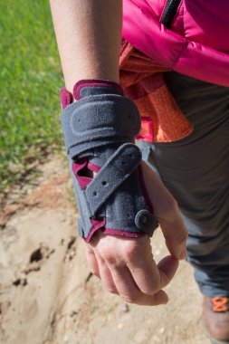 Caucasian woman wearing a resting splint to protect her injured hand. Outdoors. Madrid. Spain