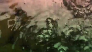 Renkli su yukarıdan sürekli akar, parlak görünür..