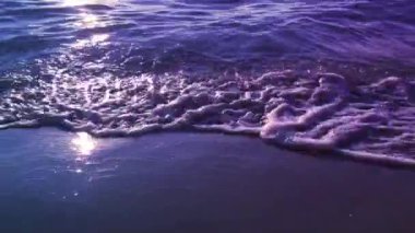 Küçük su dalgaları sürekli kıyıya doğru hareket eder..