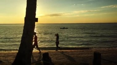 Tayland 'da sahilde yürüyen insanlar.