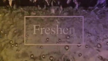 The moving water surface reflects the light continuously, looks natural and has white lettering as a composition.