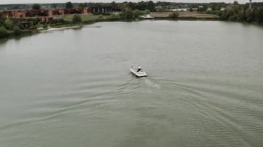 Yeşil bir gölde yelken açan bir teknenin drone görüntüsü