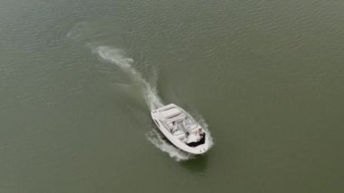 Yeşil bir gölde yelken açan bir teknenin drone görüntüsü