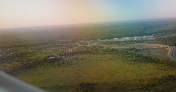 Vista desde el avión hasta el denso bosque y la carretera — Vídeos de Stock