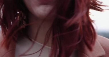 Mutlu kadın gün batımında vahşi çayırda kendine sarılıyor.