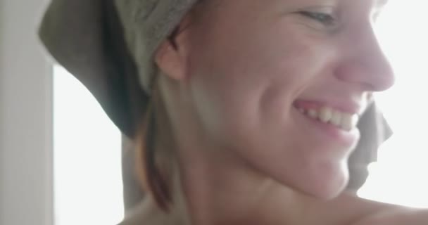 Ung rödhårig kvinna sitter på fönsterbrädan och ler mot kameran. — Stockvideo