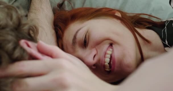 Vrouw kijkt naar een man, liggend in bed in de ochtend van dichtbij bekijken. — Stockvideo