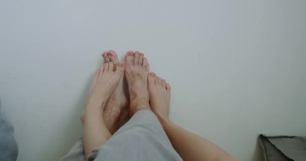 幸せな男と女は白い壁に足を置くと戦う — ストック動画