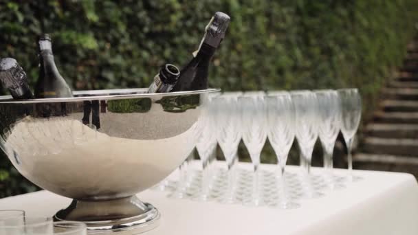 Szklanki i butelki szampana w srebrnej misce przy stole — Wideo stockowe