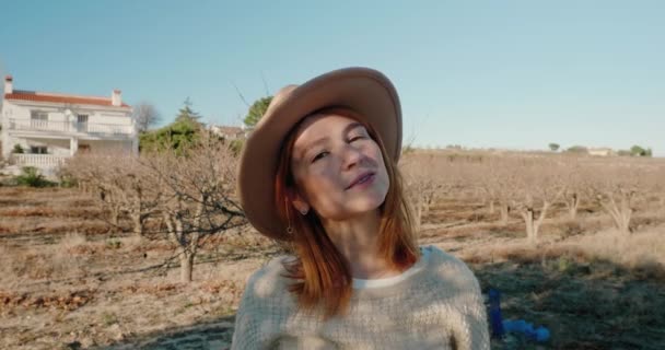 Redhead woman in stylish hat looking in camera — Vídeo de Stock