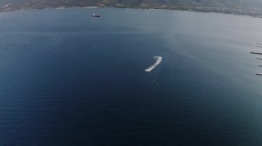 Hızlı motorlu tekne su yüzeyinde köpük izi bırakıyor.