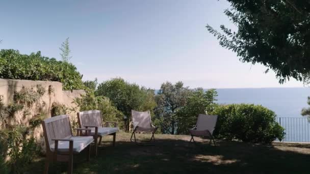 Observation deck with wooden chairs on hill overlooking sea — Video