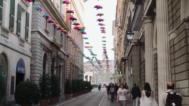 Menschen gehen in einer Stadt mit historischen Gebäuden durch eine Fußgängerzone — Stockvideo