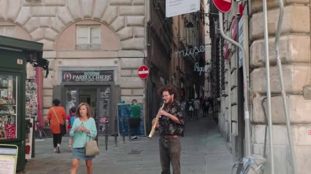 Musician plays wind instrument for people walking on street — Video Stock