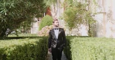 Genç damat düğün töreninde lüks çiçek buketlerinin yanında yürür.