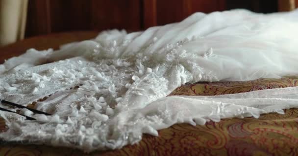 Egy fényűző fehér esküvői ruha fekszik az ágyon, készülve az esküvőre.. — Stock videók