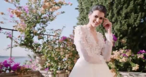 Молода жінка в білій весільній сукні вокон на балконі на екзотичному острові. закрити — стокове відео