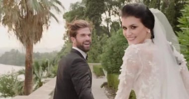 Genç evli çift Isola Del Garda 'da yolda yürür ve kameraya bakar..